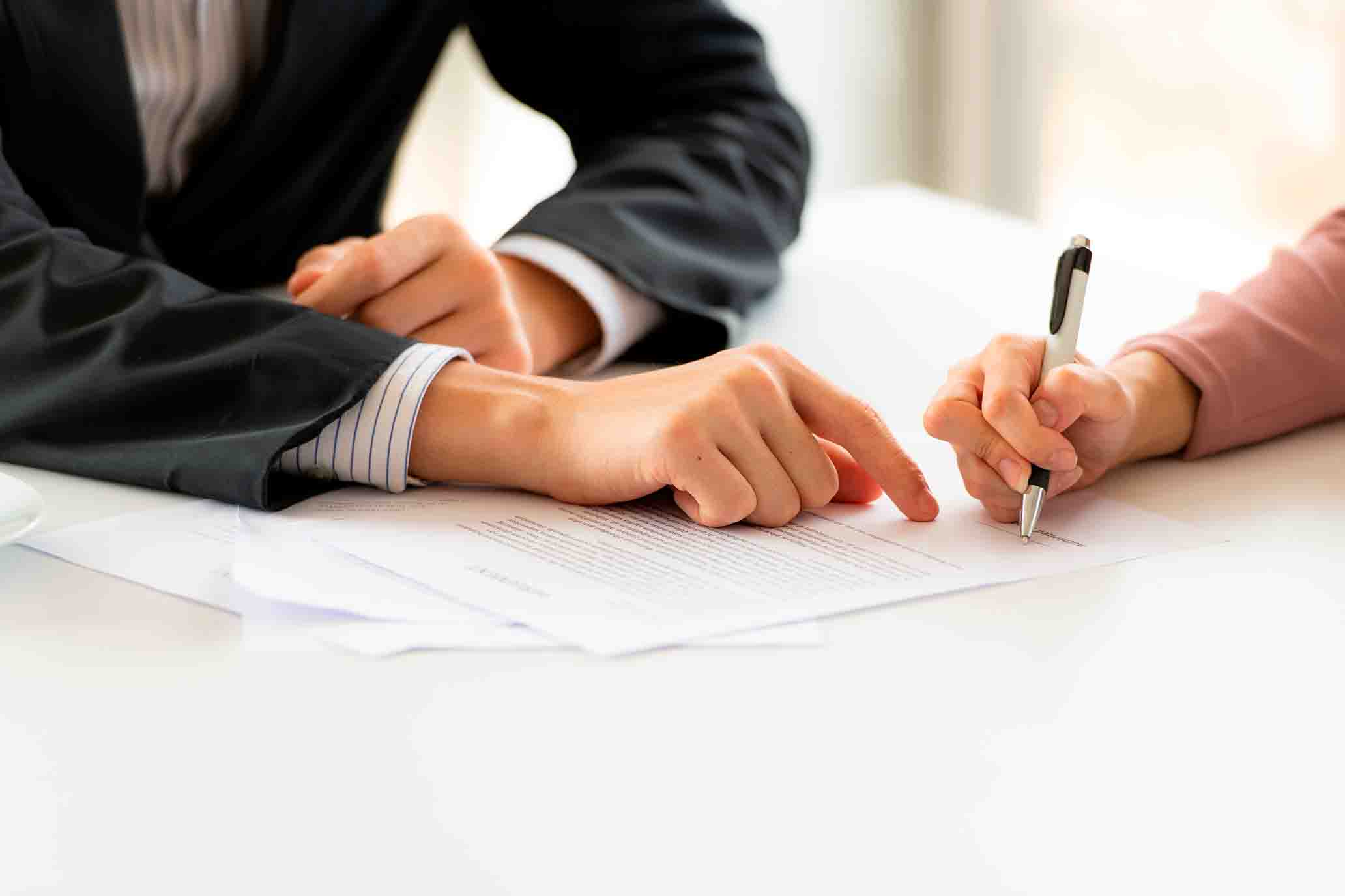 Firma de un contrato de trabajo redactado por abogados.